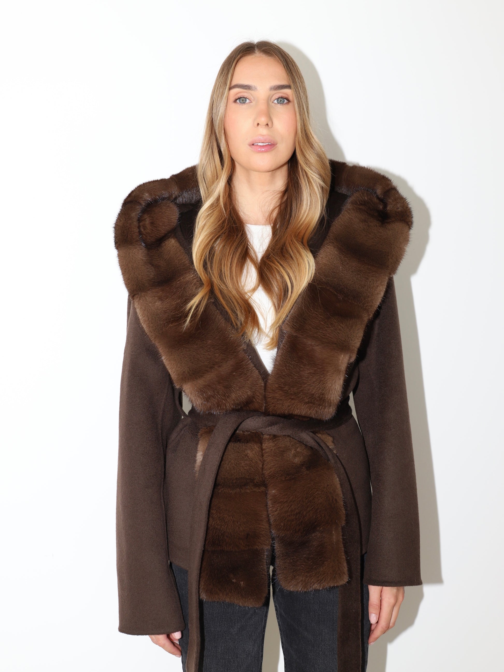 Front view of The Ayla Coat with mink fur trim, belted waist and elegant winter silhouette
