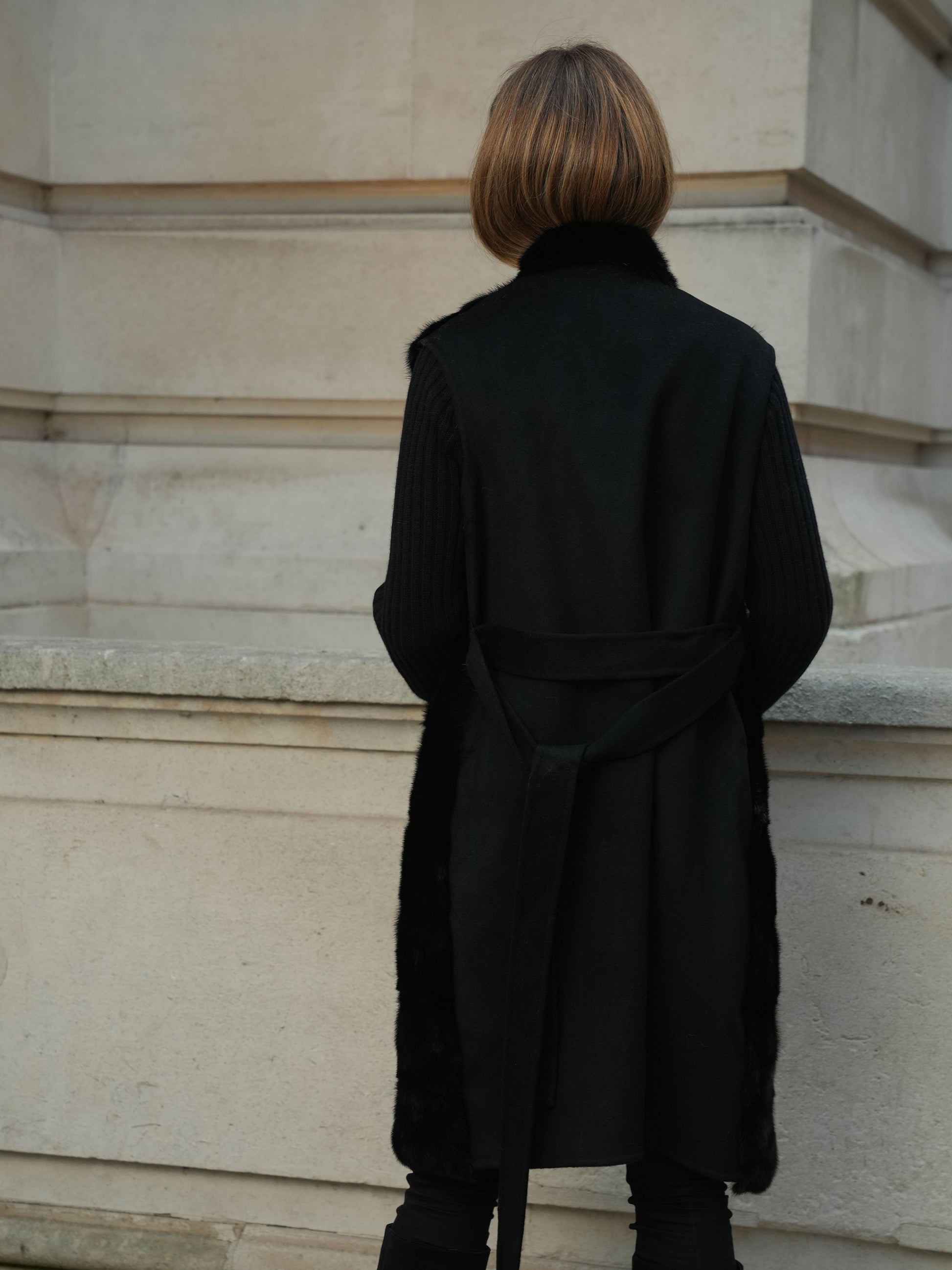 Back view of The Vera Gilet in black showing the cashmere wool blend back and belted fit