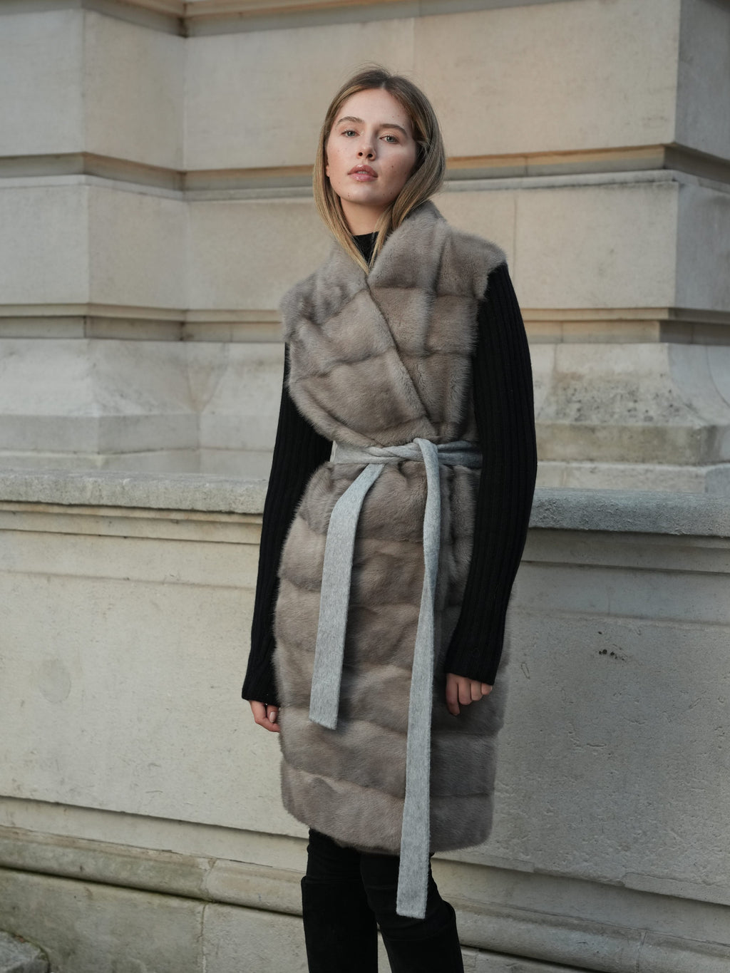 Full length front view of The Vera Mink Gilet in grey with a sleeveless fur front and tie belt
