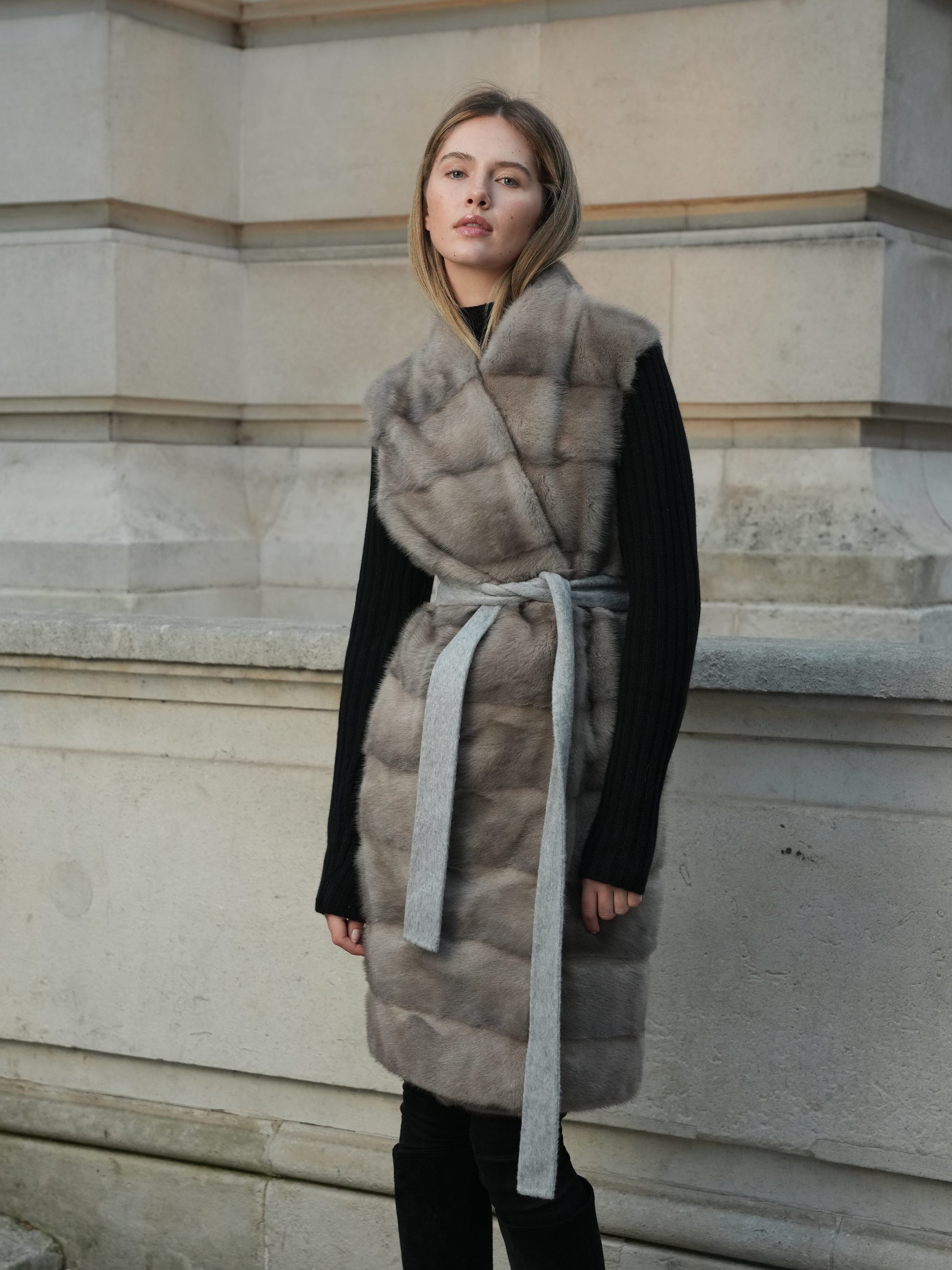Full length front view of The Vera Mink Gilet in grey with a sleeveless fur front and tie belt