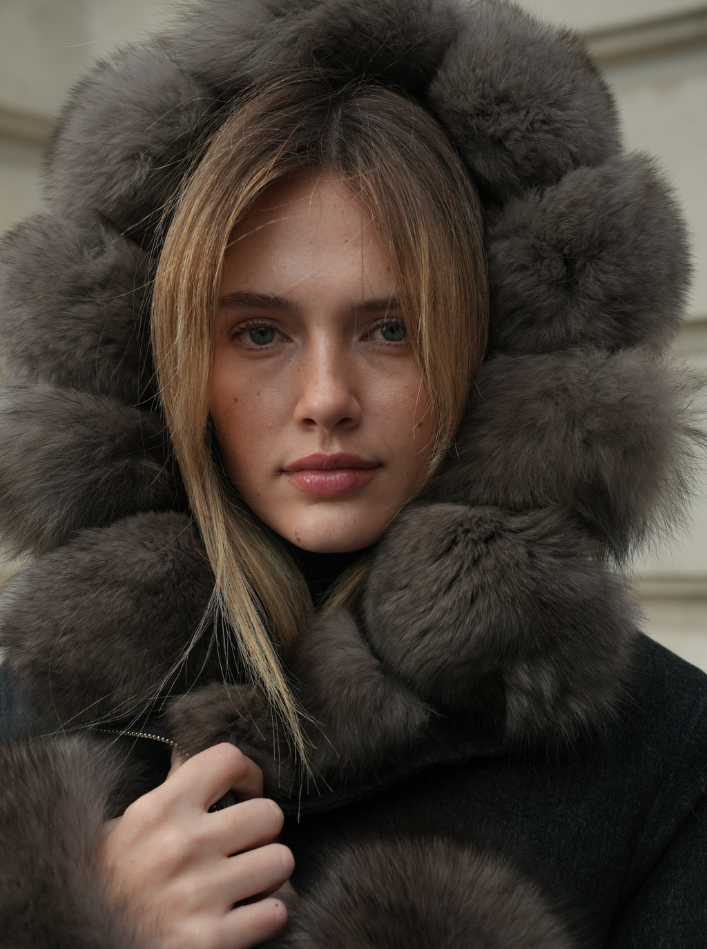 Close-up of women’s merino wool coat with large fox fur lined hood in dark grey
