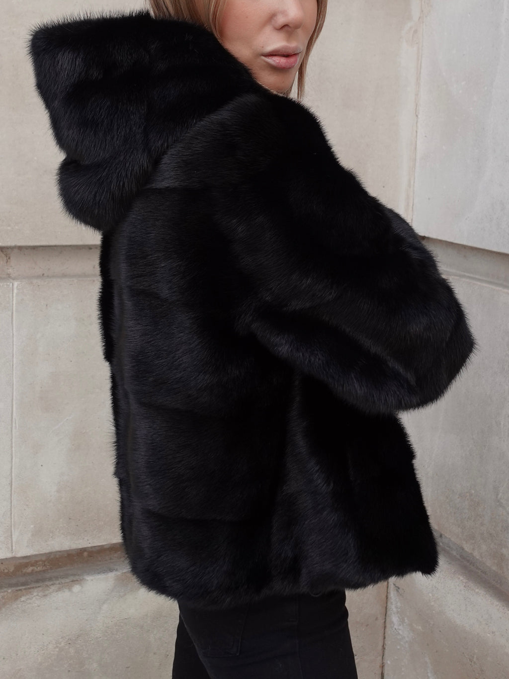 Side detail of The Hooded Black Alexandra Mink Coat showing soft pure mink fur texture