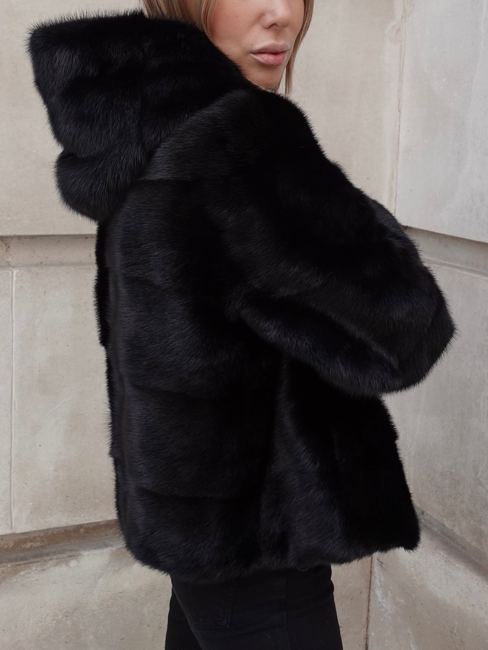 Side detail of The Hooded Black Alexandra Mink Coat showing soft pure mink fur texture